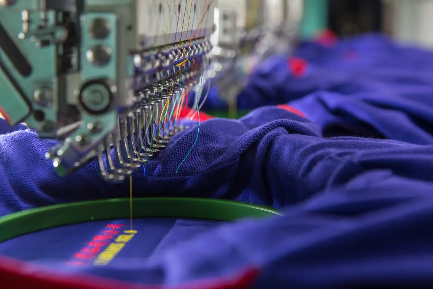 an embroidery machine stitching a design onto a blue garment